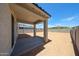 Covered patio overlooking the large dirt backyard enclosed with block fence, ideal for entertaining at 18244 W Daley Ln, Surprise, AZ 85387