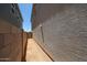 Exterior side yard view, featuring stucco and block wall; walkway between homes at 18244 W Daley Ln, Surprise, AZ 85387