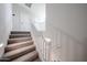Carpeted stairs with white railing lead to the upper level, providing an airy feel at 18244 W Daley Ln, Surprise, AZ 85387