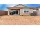 View of the home's backyard with tan stucco, a covered patio, and a small window at 10347 S Saguaro Dr, Apache Junction, AZ 85120