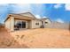 View of the home's backyard with tan stucco, a covered patio, and a block wall at 10347 S Saguaro Dr, Apache Junction, AZ 85120