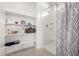 Bright bathroom featuring open shelving for storage and a shower with neutral patterned curtain at 10347 S Saguaro Dr, Apache Junction, AZ 85120
