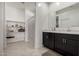 Bright bathroom featuring a double vanity, marble counters and open shelving for storage at 10347 S Saguaro Dr, Apache Junction, AZ 85120