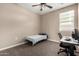 Neutral bedroom featuring a ceiling fan, carpet flooring and adjacent desk at 10347 S Saguaro Dr, Apache Junction, AZ 85120