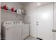 Clean laundry room with side-by-side washer and dryer, shelving and access to the exterior at 10347 S Saguaro Dr, Apache Junction, AZ 85120