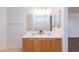 Bathroom featuring double sinks, wood cabinets, and a large mirror at 1037 E Dust Devil Dr, San Tan Valley, AZ 85143