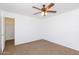 Comfortable bedroom includes a ceiling fan, neutral carpet, a closet view, and white walls at 1037 E Dust Devil Dr, San Tan Valley, AZ 85143