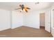 Bedroom featuring a ceiling fan, neutral carpet, and large window at 1037 E Dust Devil Dr, San Tan Valley, AZ 85143