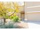 Two-story home with a tan stucco exterior, two-car garage, and low-maintenance desert landscaping at 1037 E Dust Devil Dr, San Tan Valley, AZ 85143