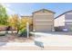 Two-story home with a tan stucco exterior, two-car garage, and low-maintenance desert landscaping at 1037 E Dust Devil Dr, San Tan Valley, AZ 85143