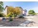 Two-story home with a tan stucco exterior, two-car garage, and low-maintenance desert landscaping at 1037 E Dust Devil Dr, San Tan Valley, AZ 85143