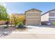 Two-story home with a tan stucco exterior, two-car garage, and low-maintenance desert landscaping at 1037 E Dust Devil Dr, San Tan Valley, AZ 85143