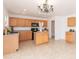 Well-appointed kitchen featuring wood cabinets, a functional island, and modern appliances for effortless meal preparation at 1037 E Dust Devil Dr, San Tan Valley, AZ 85143
