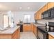 Bright kitchen with oak cabinets, neutral countertops and flooring, and modern appliances at 1037 E Dust Devil Dr, San Tan Valley, AZ 85143