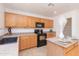 Bright kitchen with black appliances, oak cabinets, and an island with dining space at 1037 E Dust Devil Dr, San Tan Valley, AZ 85143