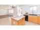 Open floor plan with kitchen island, black appliances, and tile flooring at 1037 E Dust Devil Dr, San Tan Valley, AZ 85143