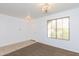 Bright, carpeted living room featuring neutral paint, decorative lighting, and natural light through a window at 1037 E Dust Devil Dr, San Tan Valley, AZ 85143