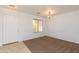 Bright, carpeted living room featuring neutral paint, decorative lighting, and natural light through a window at 1037 E Dust Devil Dr, San Tan Valley, AZ 85143