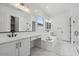 The luxurious bathroom features dual vanities, a soaking tub and a separate glass-enclosed shower at 11432 E Utopia Ave, Mesa, AZ 85212
