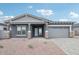 Charming single-Gathering home showcasing a gray exterior, brick accents, and a paved driveway at 11432 E Utopia Ave, Mesa, AZ 85212