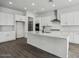 Modern kitchen with white cabinets, island, and stainless steel appliances at 11432 E Utopia Ave, Mesa, AZ 85212