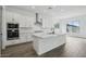Bright kitchen features white cabinets, stainless steel appliances and a large center island with quartz countertops at 11432 E Utopia Ave, Mesa, AZ 85212