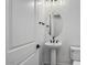 A powder room with a pedestal sink, a round mirror, and modern fixtures at 11432 E Utopia Ave, Mesa, AZ 85212