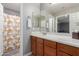 Bathroom with wood cabinets, a large mirror, and a shower/tub with a patterned curtain at 1147 E Lodgepole Dr, Gilbert, AZ 85298