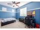 Bright blue bedroom with a ceiling fan, comfortable bed, and a built-in desk at 1147 E Lodgepole Dr, Gilbert, AZ 85298