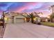 Expansive driveway leads to a three-car garage and beautifully landscaped front yard with mature palm trees at 1147 E Lodgepole Dr, Gilbert, AZ 85298