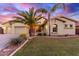 Charming single-Gathering home boasts a lush lawn, desert landscaping, and majestic palm trees at 1147 E Lodgepole Dr, Gilbert, AZ 85298