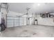 Spacious three-car garage featuring white doors, clean floors, and overhead storage racks at 1147 E Lodgepole Dr, Gilbert, AZ 85298