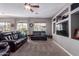 Spacious living room featuring cozy leather sofas, large windows, and a ceiling fan at 1147 E Lodgepole Dr, Gilbert, AZ 85298