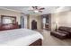 Bright primary bedroom with a large bed, dark wood furniture, and an ensuite bathroom at 1147 E Lodgepole Dr, Gilbert, AZ 85298