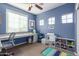 Office space with blue walls, multiple windows, a built-in desk, and shelving at 1147 E Lodgepole Dr, Gilbert, AZ 85298