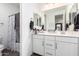 Bathroom with double vanity, mirrors, and a shower/tub combo with white cabinets at 11574 W Levi Dr, Avondale, AZ 85323