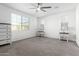 Bright bedroom with a ceiling fan, three windows, and neutral carpet at 11574 W Levi Dr, Avondale, AZ 85323