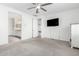 Spacious bedroom with a wall-mounted TV and view to the bathroom and hallway at 11574 W Levi Dr, Avondale, AZ 85323