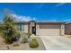 Charming single-story home featuring desert landscaping, a stone facade, and a two-car garage at 11574 W Levi Dr, Avondale, AZ 85323