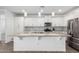 Modern kitchen features white cabinets, stainless steel appliances, and a large central island at 11574 W Levi Dr, Avondale, AZ 85323