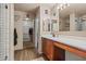Bright bathroom features a wooden vanity, walk-in shower with white tiling, and a large walk-in closet for storage at 11732 W Foothill Dr, Sun City, AZ 85373