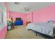Vibrant bedroom featuring colorful pink walls, modern furniture, and ample natural light at 11732 W Foothill Dr, Sun City, AZ 85373