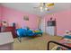 ' bedroom with pink walls, ceiling fan, carpet, and a view into the hallway at 11732 W Foothill Dr, Sun City, AZ 85373