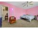 Bright pink bedroom featuring a comfortable chair and decor and a stylish ceiling fan at 11732 W Foothill Dr, Sun City, AZ 85373