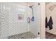 The walk-in shower has tiled walls, pebble flooring, glass doors, and a mounted shower head and shelf at 11732 W Foothill Dr, Sun City, AZ 85373