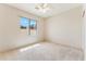 Bright bedroom features neutral carpet, ceiling fan, and a window with a view at 1245 E Waterview Pl, Chandler, AZ 85249