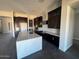 Modern kitchen with white countertops, dark cabinets, stainless steel appliances, and an island at 13382 E Sand Hills Rd, Scottsdale, AZ 85255
