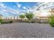 A spacious backyard with gravel landscaping, mature trees, and privacy fencing for a serene outdoor space at 136 N 236Th Ave, Buckeye, AZ 85396