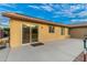 A home's backyard showcasing a large concrete patio and sliding glass doors for seamless indoor-outdoor living at 136 N 236Th Ave, Buckeye, AZ 85396