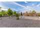Backyard with gravel landscaping, mature trees, and a patio area for relaxation and entertainment at 136 N 236Th Ave, Buckeye, AZ 85396